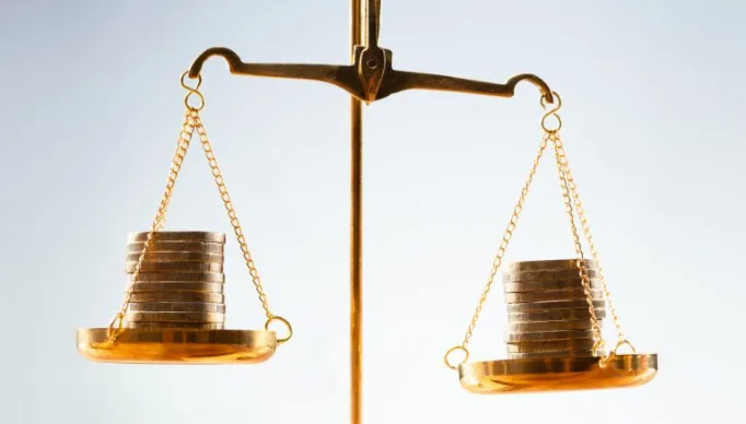 Balança com moedas nos dois pratos - busca pelo equilíbrio das contas